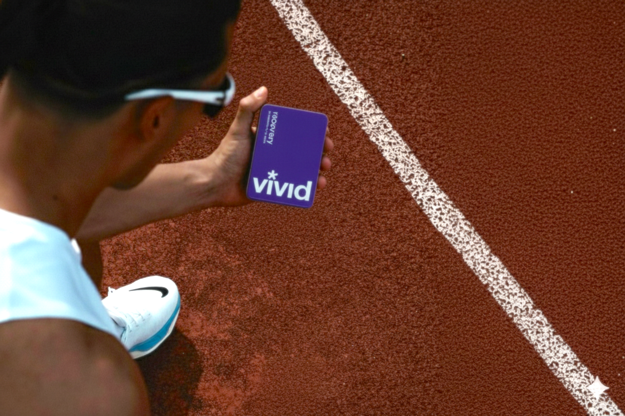 A runner holding a tin of Vivid Recovery, a hangover recovery and support supplement