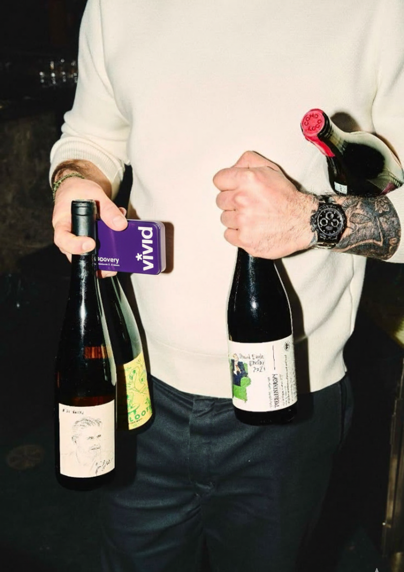 Person holding three wine bottles with box of hangover recovery vivid tin